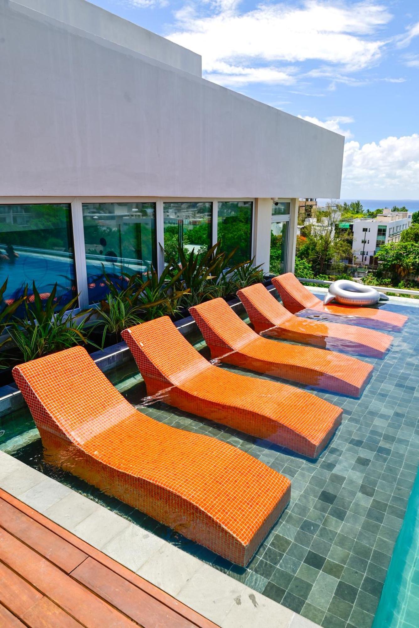 Aloft Playa Del Carmen Hotel ภายนอก รูปภาพ Sunbathing chairs at a pool